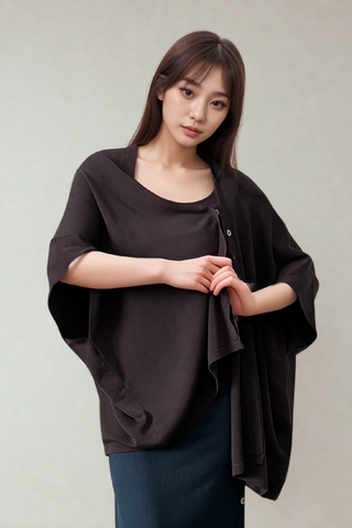 A woman stands against a neutral background, wearing the Olive Basics Deborah Nursing Kimono Cardigan and a ribbed skirt, looking at the camera with a calm expression.