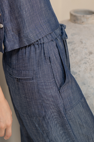 Close-up of a person wearing Olive Basics Bella Multi-Pocket Drawstring Pants in blue TENCEL linen blend, featuring an elastic waistband, front pockets, and a relaxed fit.