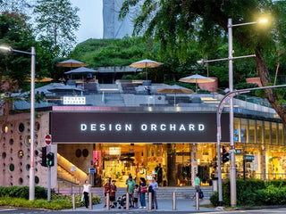 Design Orchard shopping complex at night with people walking around.